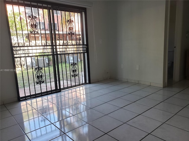 tiled spare room with a healthy amount of sunlight