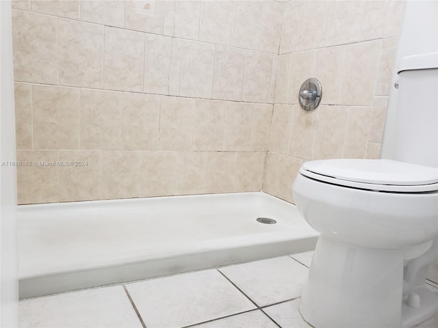 bathroom featuring tile patterned flooring, toilet, and walk in shower