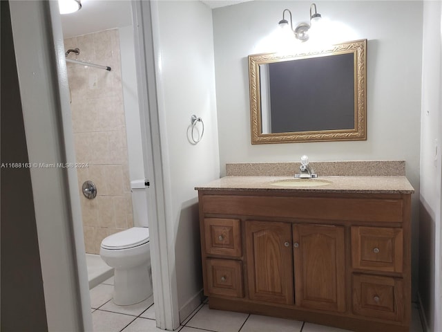 bathroom featuring tile patterned floors, vanity, toilet, and tiled shower