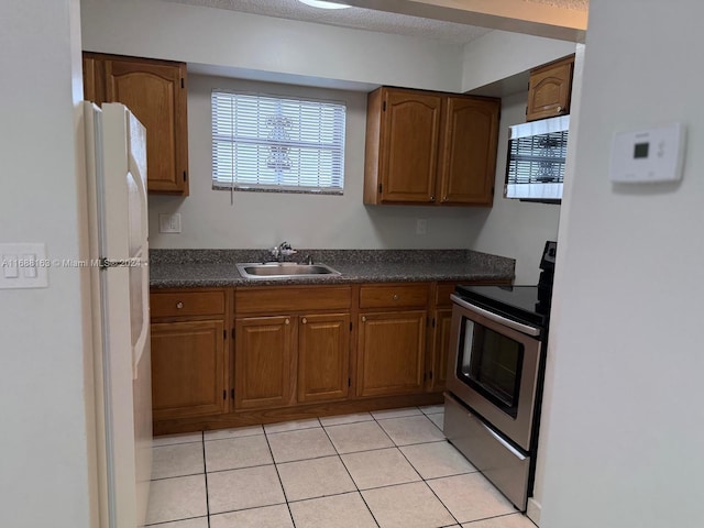 kitchen with appliances with stainless steel finishes, light tile patterned floors, and sink