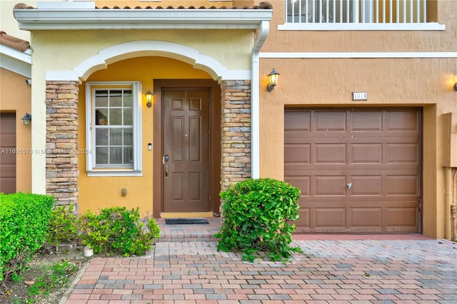 doorway to property featuring a garage and a balcony