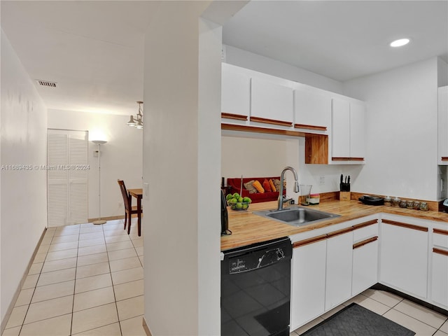 kitchen featuring white cabinetry, sink, light tile patterned flooring, and black dishwasher