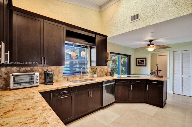 kitchen with plenty of natural light, sink, stainless steel dishwasher, and a textured ceiling