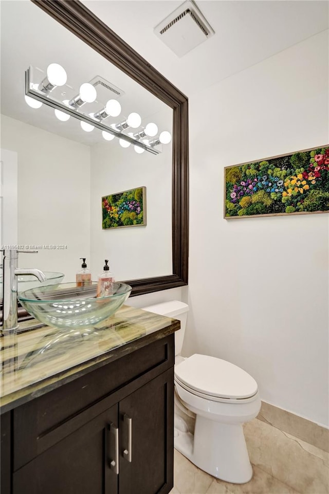 bathroom with tile patterned flooring, vanity, and toilet