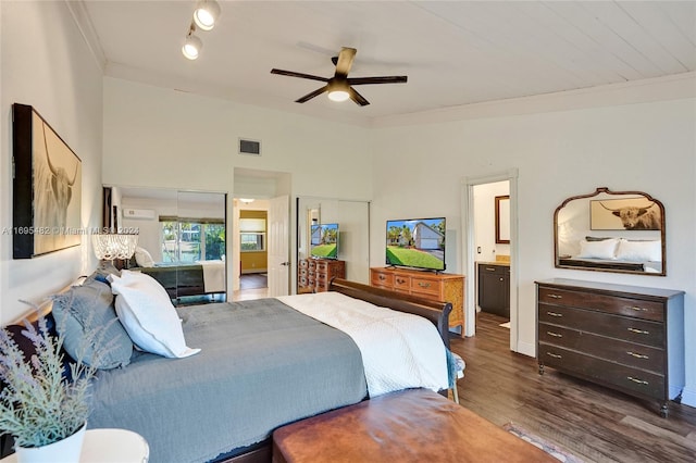 bedroom featuring connected bathroom, dark hardwood / wood-style floors, ceiling fan, and ornamental molding