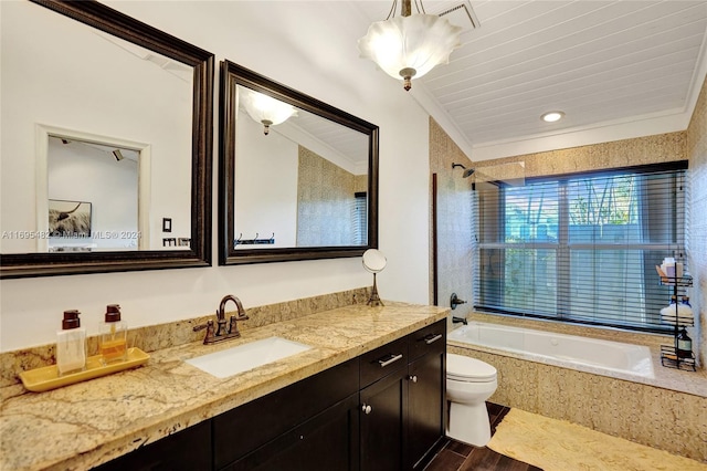 full bathroom featuring hardwood / wood-style floors, vanity, tiled shower / bath, toilet, and ornamental molding