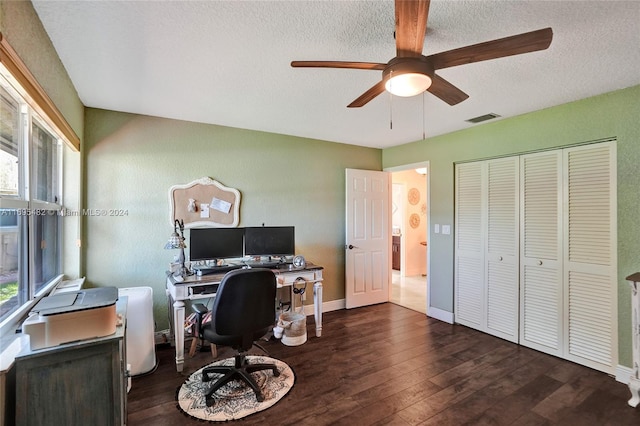 home office with a healthy amount of sunlight, a textured ceiling, ceiling fan, and dark wood-type flooring