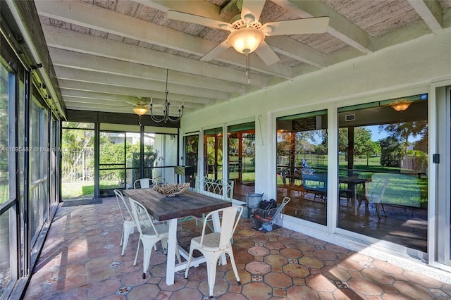 sunroom / solarium featuring beamed ceiling and ceiling fan