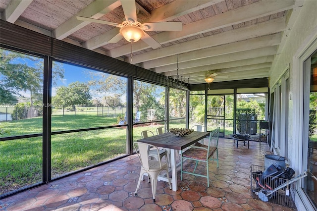 unfurnished sunroom with beamed ceiling, ceiling fan, and wooden ceiling