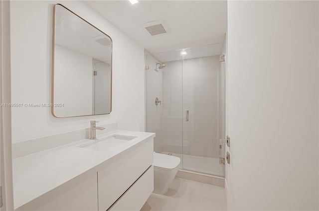 bathroom featuring a shower with door, vanity, and toilet