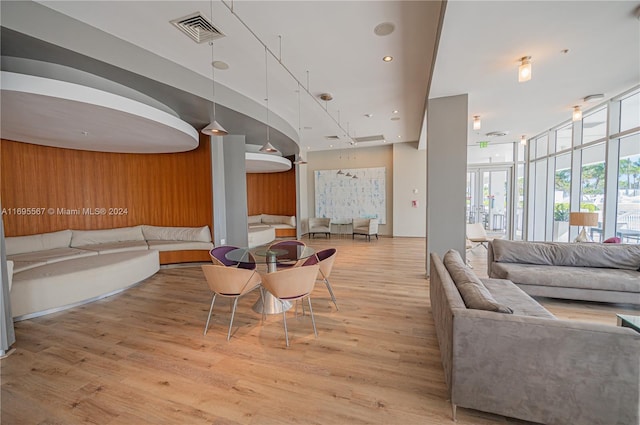 interior space featuring hardwood / wood-style floors, wood walls, and a towering ceiling