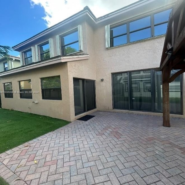 back of house with a yard and a patio