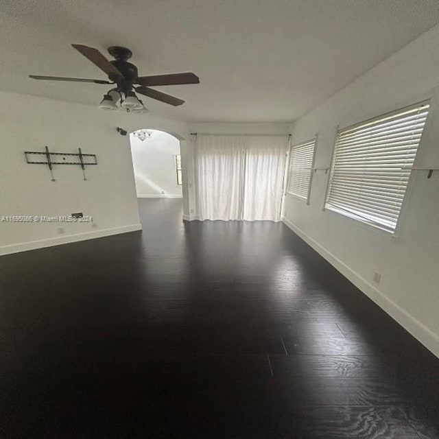 empty room featuring ceiling fan and dark hardwood / wood-style flooring