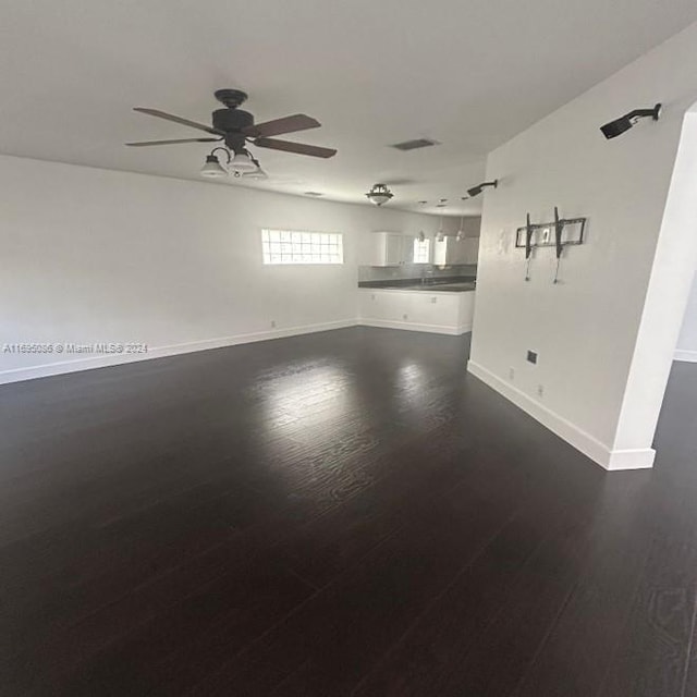 unfurnished living room featuring dark hardwood / wood-style floors and ceiling fan