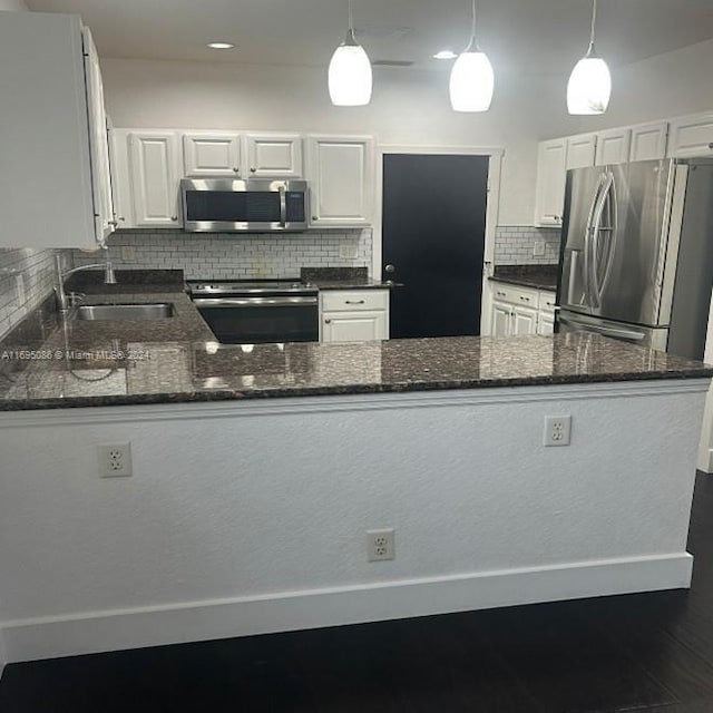 kitchen featuring white cabinets, stainless steel appliances, and hanging light fixtures