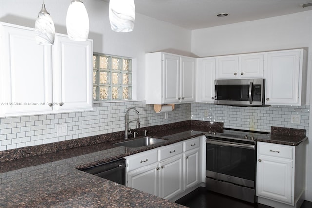 kitchen with white cabinetry, sink, hanging light fixtures, dark stone counters, and appliances with stainless steel finishes