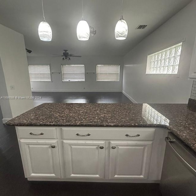 kitchen with pendant lighting, dark stone counters, white cabinetry, and stainless steel dishwasher