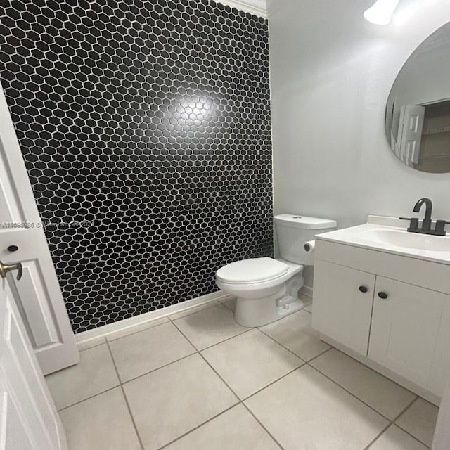 bathroom with toilet, vanity, and tile patterned floors