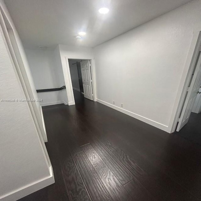 unfurnished room with dark wood-type flooring