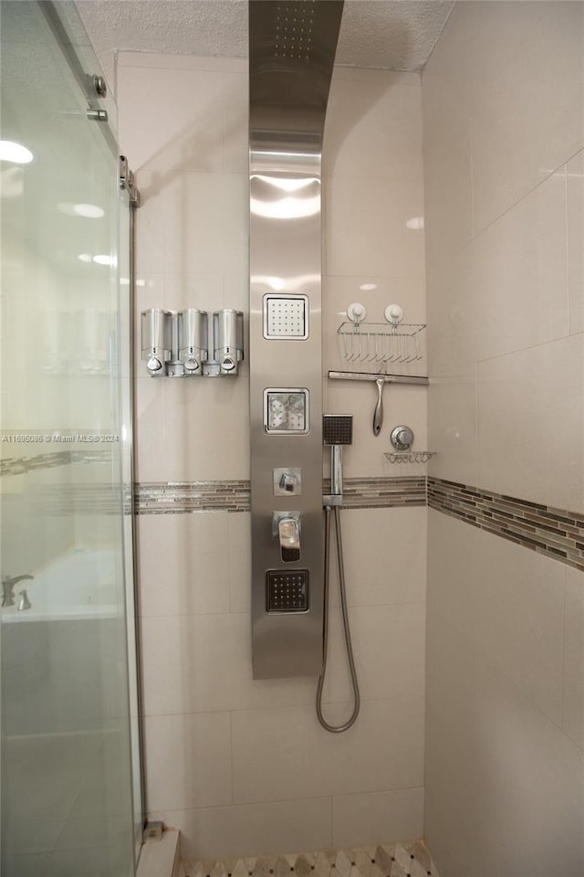 bathroom featuring an enclosed shower and a textured ceiling