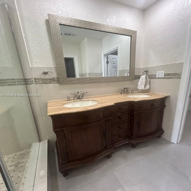 bathroom featuring tile patterned floors, vanity, and a shower