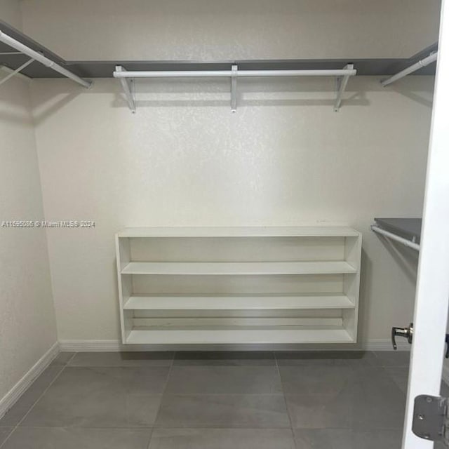 walk in closet featuring dark tile patterned flooring