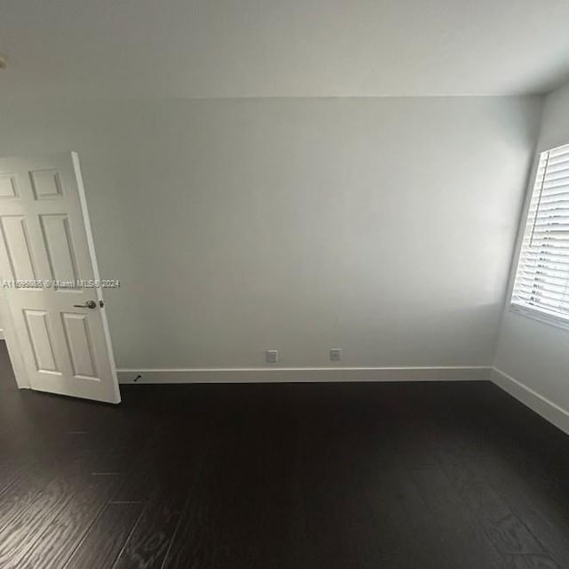 empty room with dark wood-type flooring