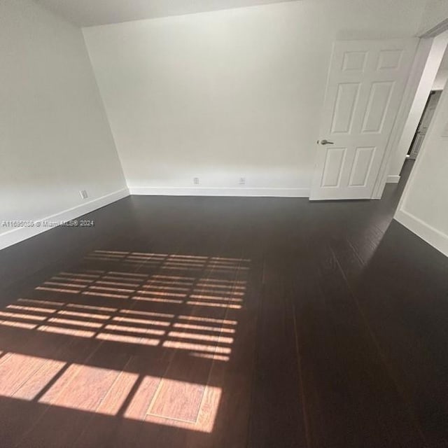 spare room with dark hardwood / wood-style flooring