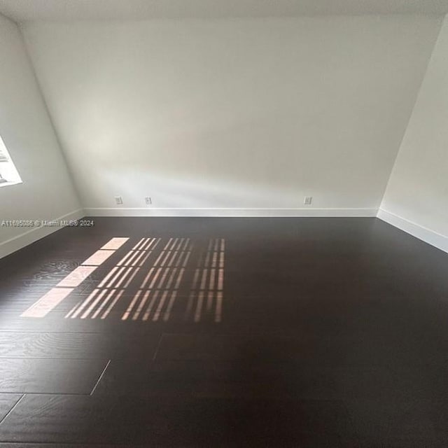 unfurnished room featuring dark wood-type flooring