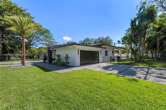 ranch-style home featuring a garage and a front lawn