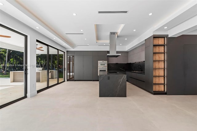 kitchen with a center island, sink, ceiling fan, double oven, and island range hood