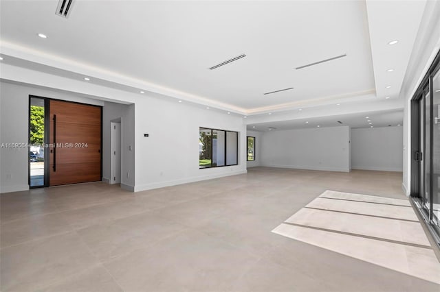 unfurnished living room featuring a tray ceiling