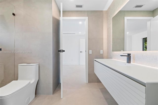 bathroom with vanity, toilet, and tile walls