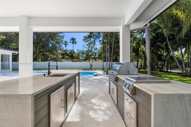 view of patio featuring a grill, a fenced in pool, exterior kitchen, and sink