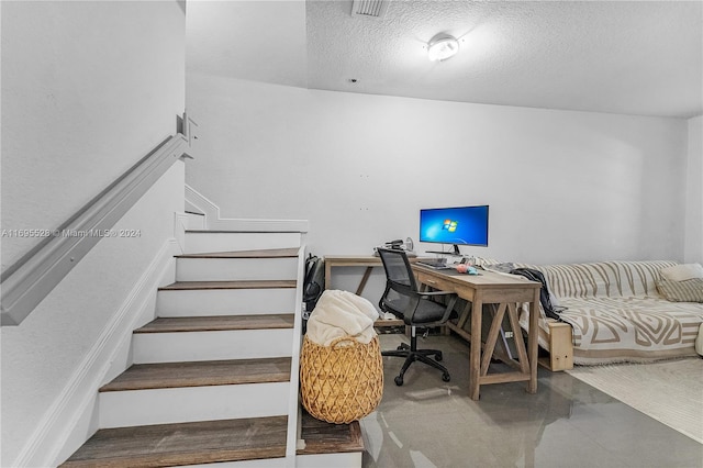 office space with concrete floors and a textured ceiling