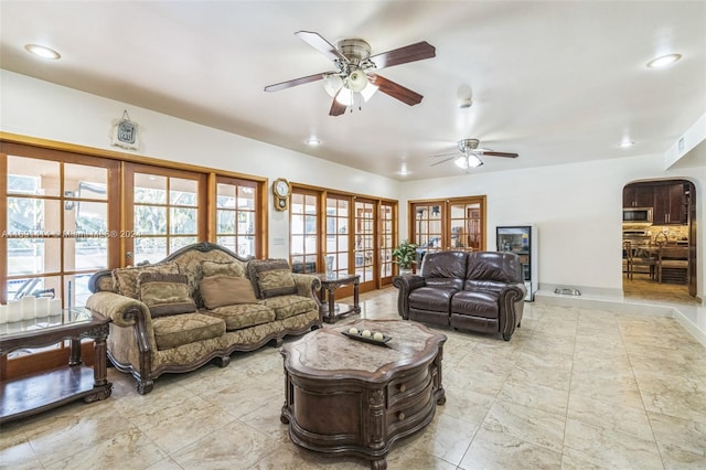 living room featuring ceiling fan and french doors