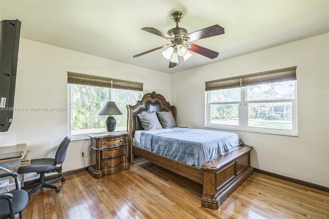 bedroom with multiple windows, ceiling fan, and light wood-type flooring