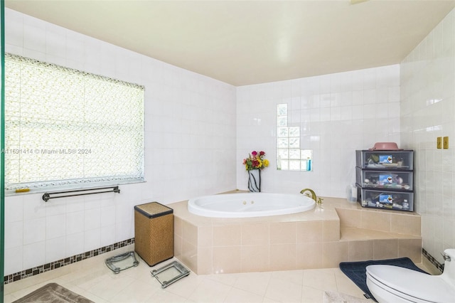 bathroom featuring tile patterned floors, tiled tub, tile walls, and toilet