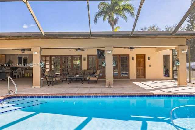 view of pool featuring glass enclosure, ceiling fan, and an outdoor living space