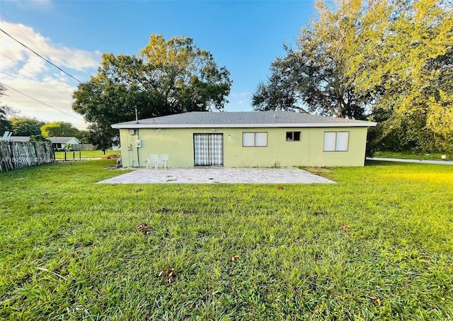 back of property featuring a patio area and a yard