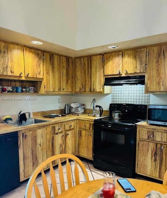 kitchen featuring light tile patterned flooring, sink, backsplash, and black appliances