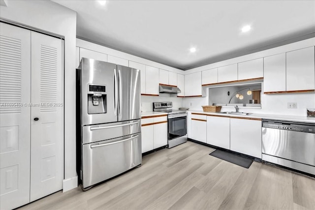 kitchen featuring sink, white cabinets, stainless steel appliances, and light hardwood / wood-style floors