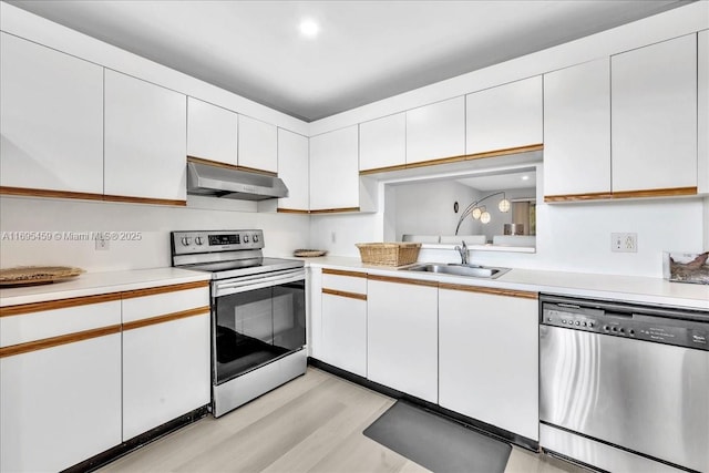 kitchen with white cabinets, light wood-type flooring, stainless steel appliances, and sink