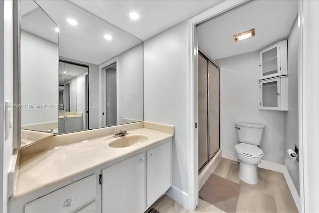 bathroom with vanity, toilet, and an enclosed shower