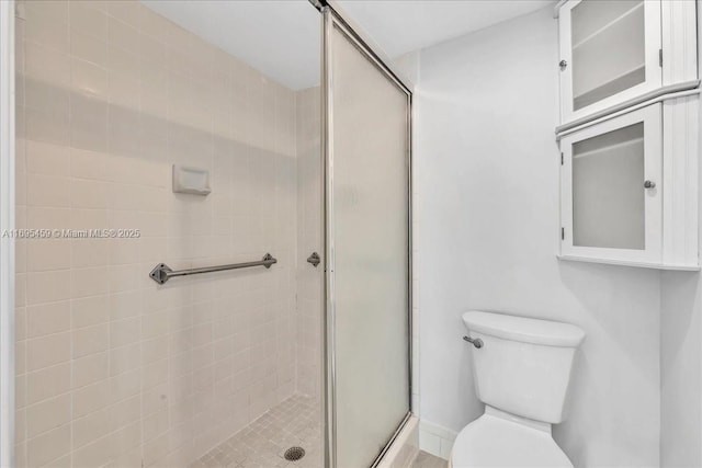 bathroom featuring toilet and an enclosed shower