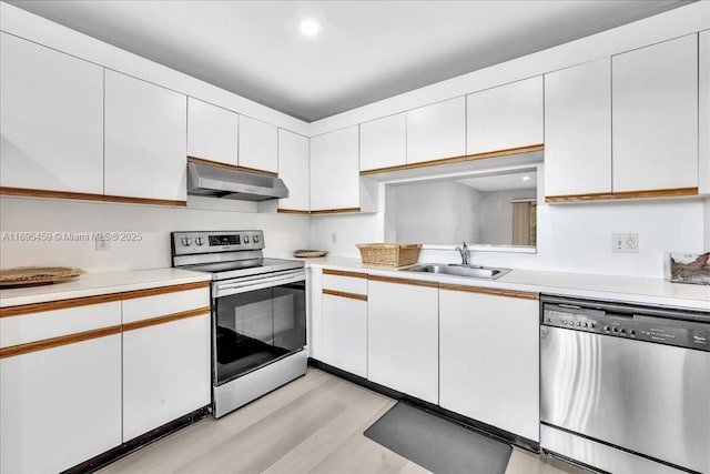 kitchen with sink, white cabinets, light wood-type flooring, and appliances with stainless steel finishes