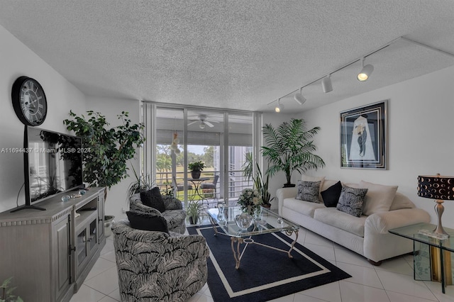 tiled living room with ceiling fan, track lighting, and a textured ceiling