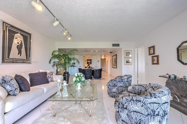 tiled living room with a textured ceiling and track lighting