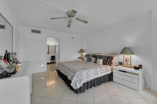 tiled bedroom featuring connected bathroom, ceiling fan, and a textured ceiling