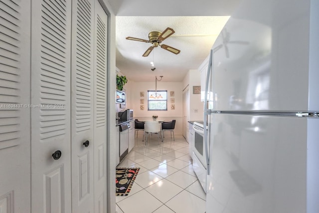 kitchen featuring a textured ceiling, white appliances, ceiling fan, light tile patterned floors, and pendant lighting